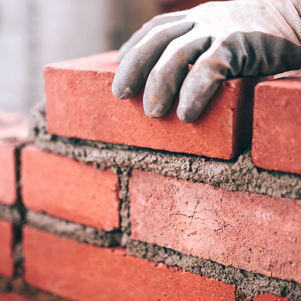 hands-red-bricks-